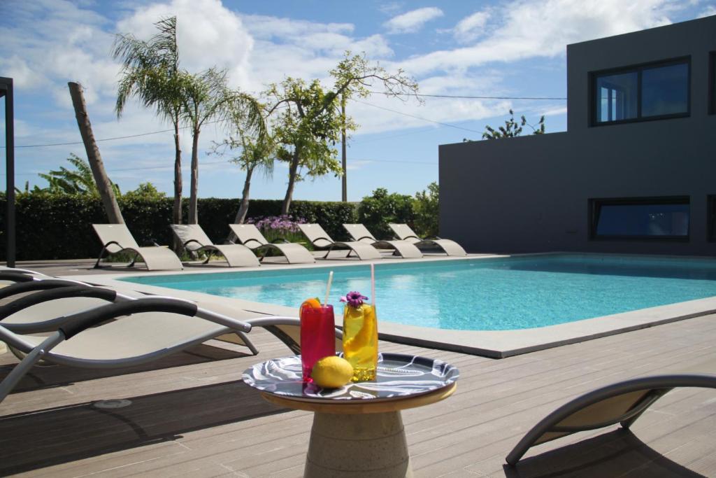 - une table avec deux boissons à côté de la piscine dans l'établissement Villas Marim, à Olhão