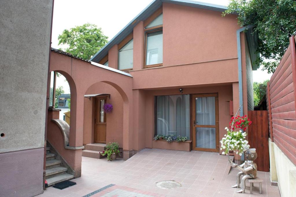 une maison rose avec une terrasse en face de celle-ci dans l'établissement Petro delux apartments, à Kaunas