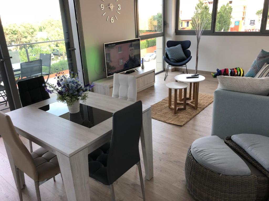 a living room with a dining table and a tv at Appartement plage Salata Rosas in Roses