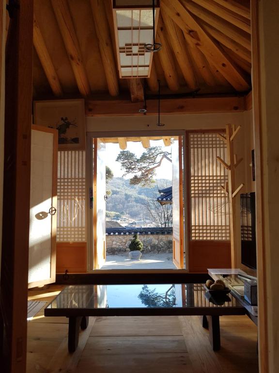 een kamer met een tafel en een groot raam bij Jukheon Traditional House in Andong