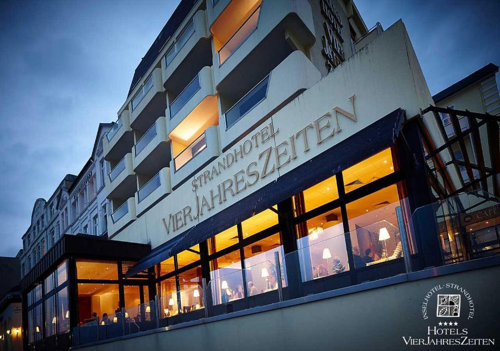 un edificio con un cartel en el costado en Strandhotel VierJahresZeiten, en Borkum