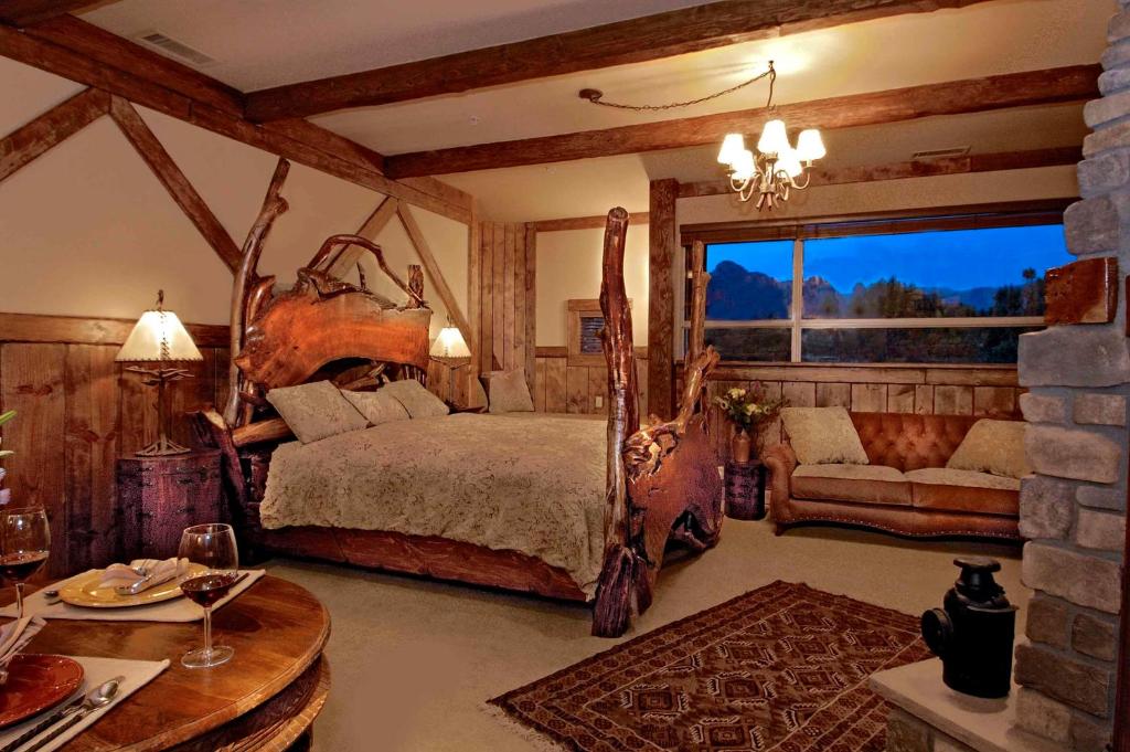 een slaapkamer met een bed, een bank en een tafel bij Adobe Grand Villas in Sedona