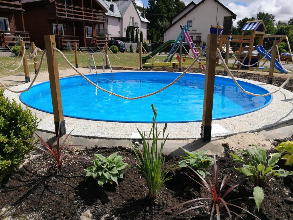 uma piscina com um baloiço num quintal em Osada Rybacka em Jastrzębia Góra