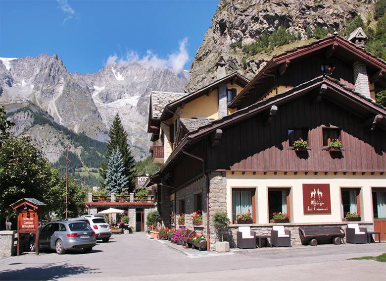 un edificio con coches estacionados frente a una montaña en Hotel Dei Camosci, en Courmayeur