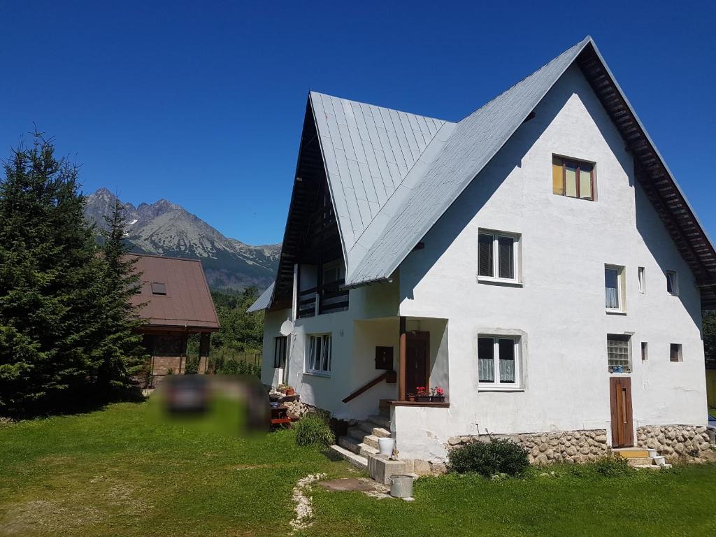 uma grande casa branca com um telhado de gambrel em Vila Valéria em Tatranská Lomnica