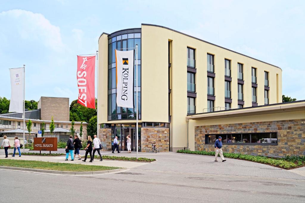 um edifício com pessoas a andar na frente dele em Hotel Susato em Soest