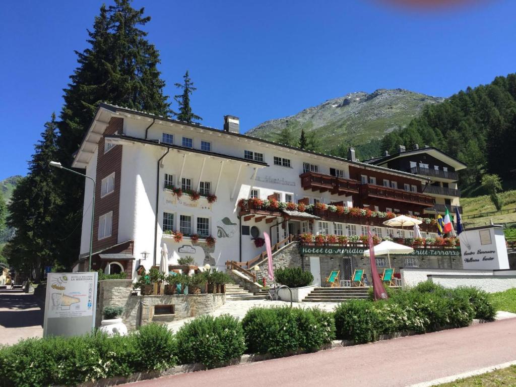 un gran edificio blanco con flores delante en Hotel La Meridiana, en Madesimo