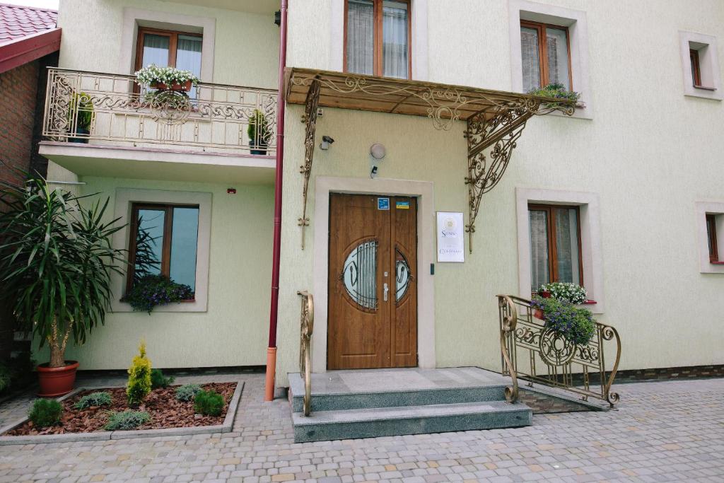 um edifício com uma porta de madeira e escadas em frente em Sunny Hotel em Lviv