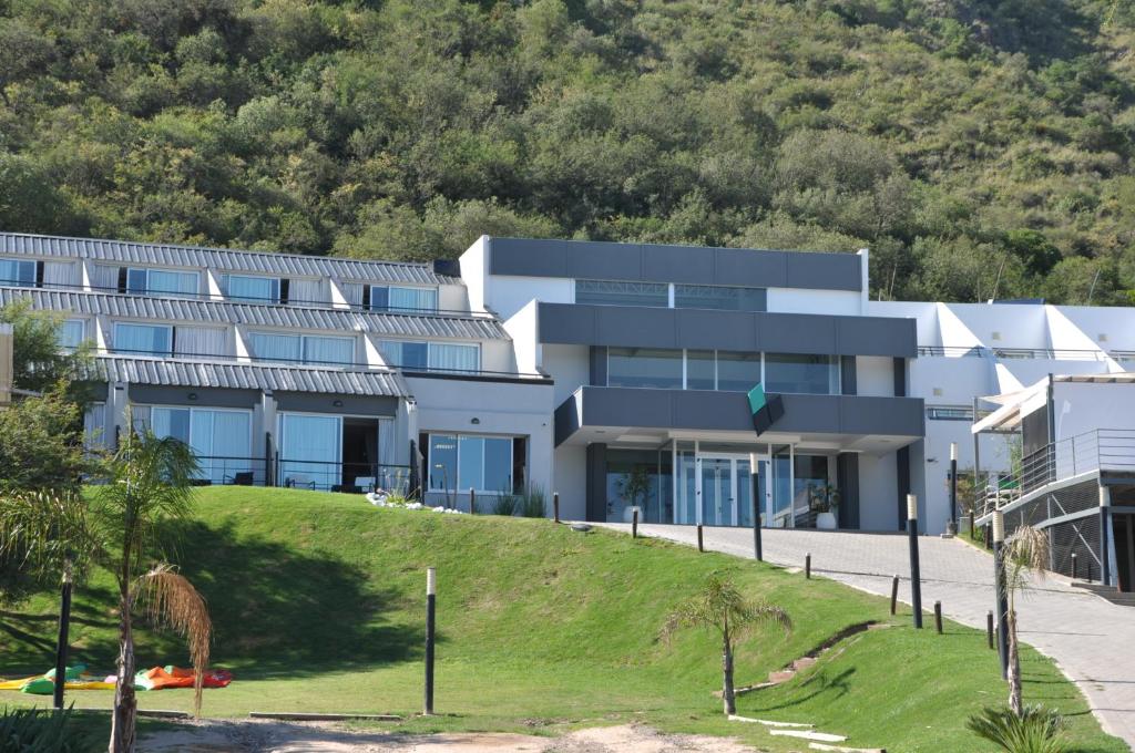 un bâtiment au sommet d'une colline plantée d'arbres dans l'établissement Pinares Panorama Suites & Spa, à Villa Carlos Paz