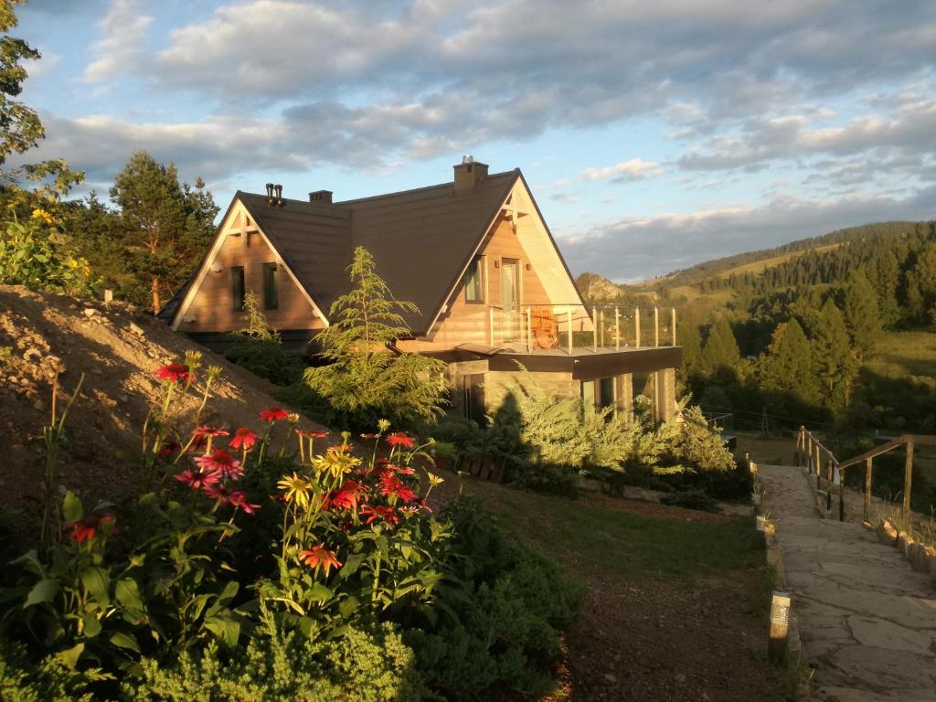 una casa su una collina con dei fiori di Jaworki Green Dream a Szczawnica