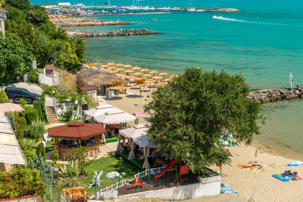 Ein Strand mit einem Haufen Regenschirme und dem Ozean in der Unterkunft Iris Beach Hotel in Sweti Wlas