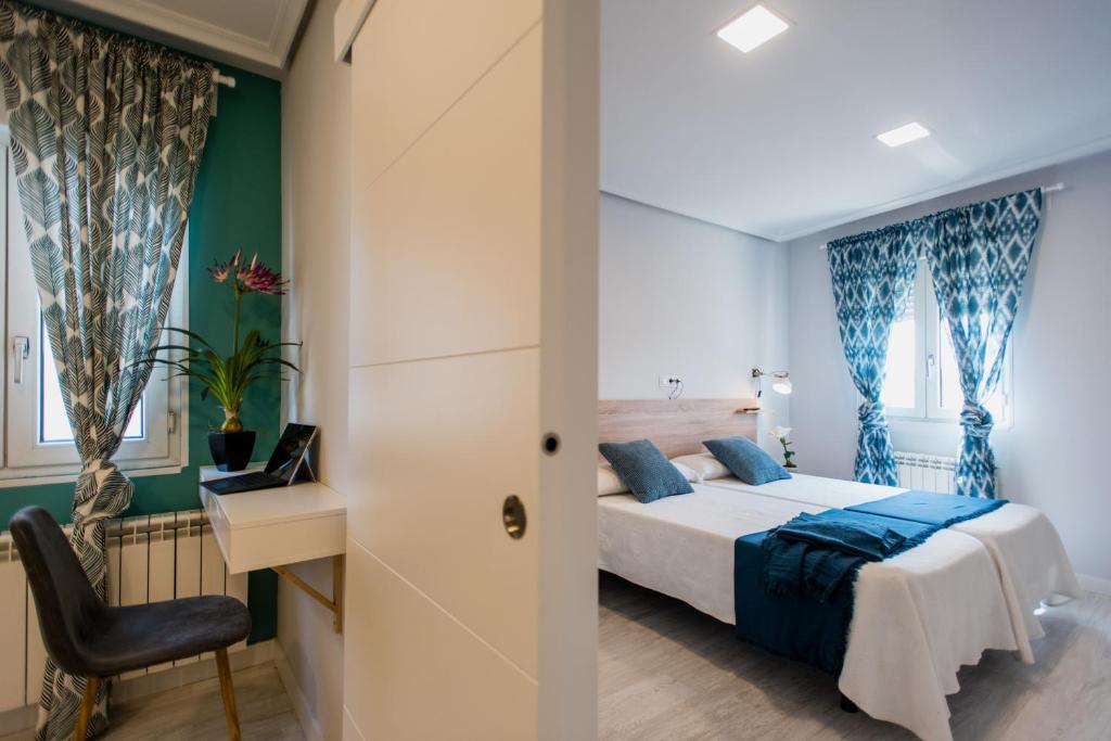 een slaapkamer met een bed, een bureau en een stoel bij Apartamentos River Santander in Santander