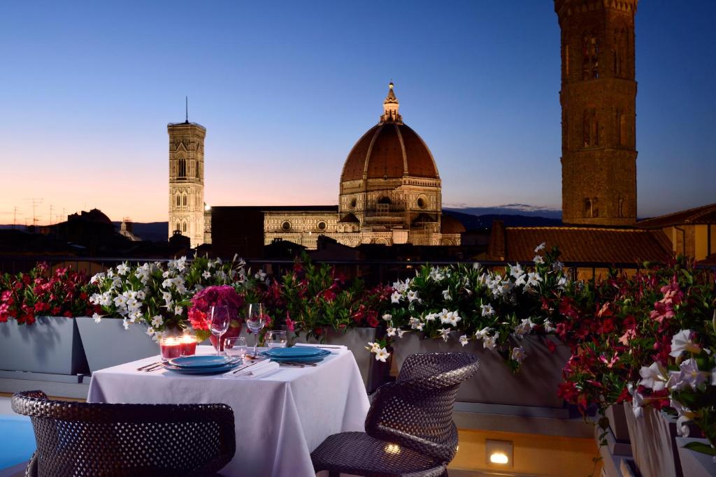 una mesa en un balcón con flores y un edificio en San Firenze Suites & Spa, en Florencia