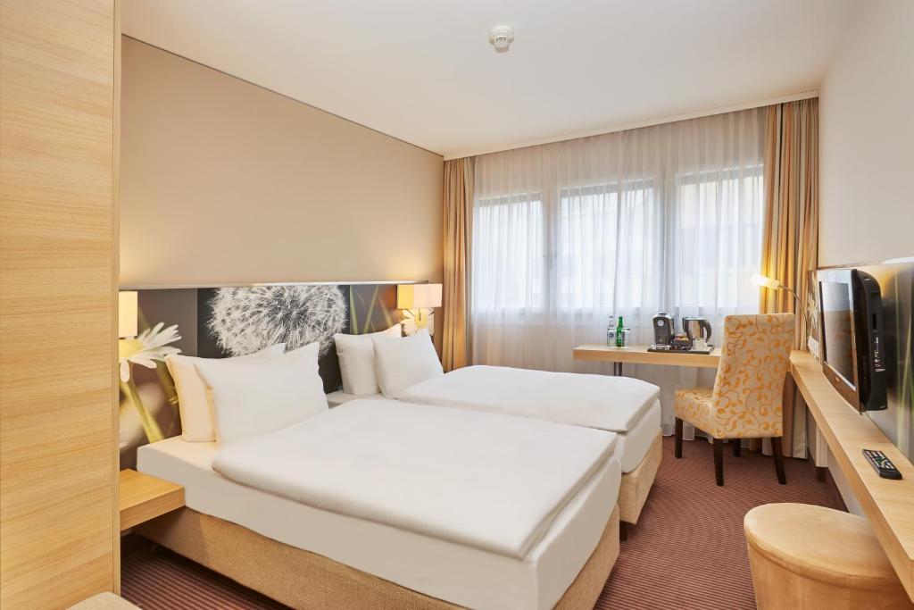 Un pat sau paturi într-o cameră la H+ Hotel Zürich