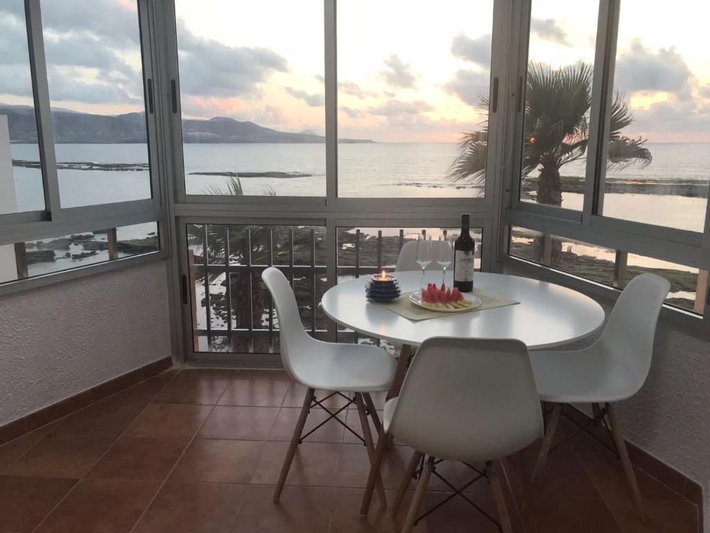 uma mesa e cadeiras num quarto com vista para o oceano em Vista Teide 305-306 em Las Palmas de Gran Canárias