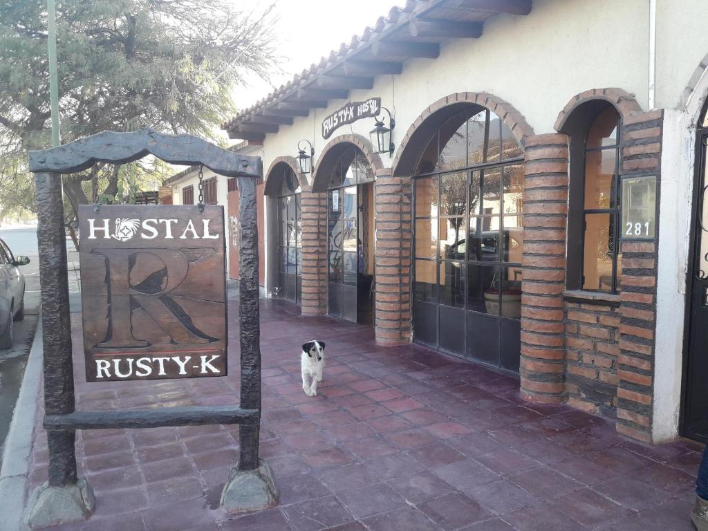 卡法亚特Hostal Rustyk的站在砖楼前的狗