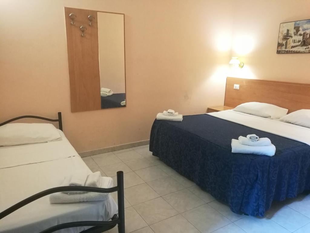 um quarto de hotel com duas camas e um espelho em Palma em Roma