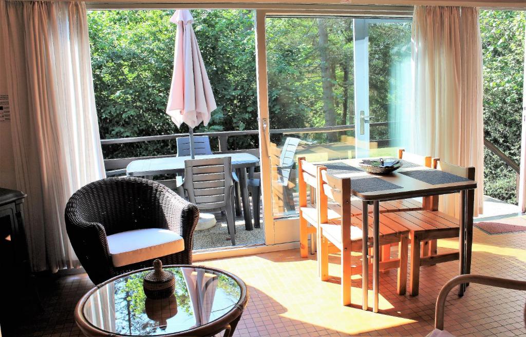 een woonkamer met een tafel en stoelen op een balkon bij Au bois charmant in Waulsort