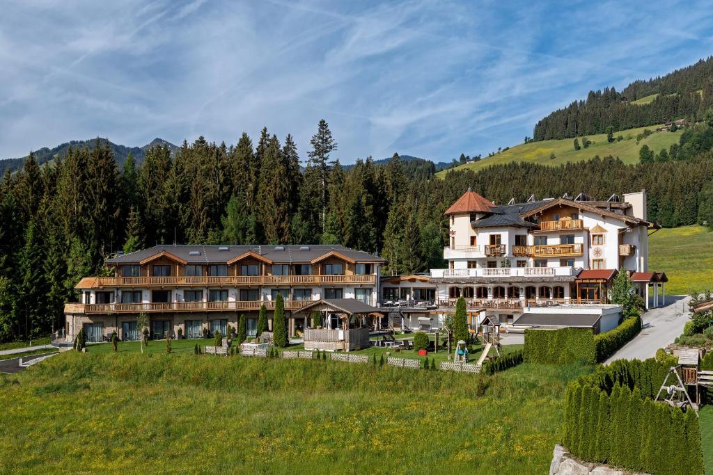 un gran hotel en una colina con un campo verde en Leamwirt, en Hopfgarten im Brixental