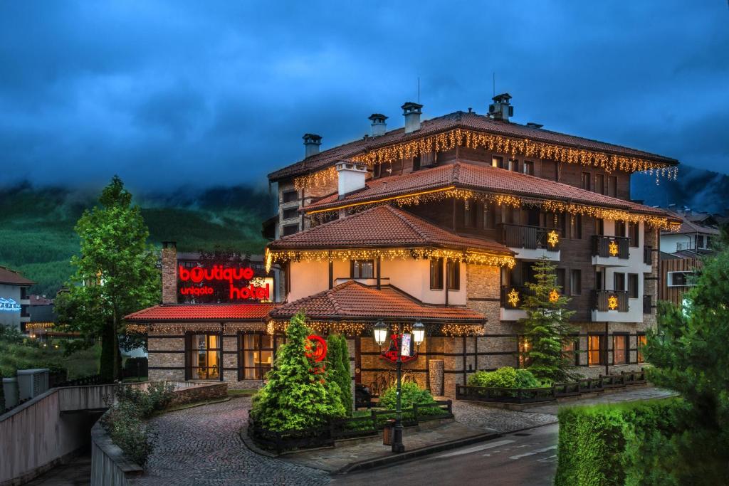 a building with a sign on the side of it at Boutique Hotel Uniqato in Bansko