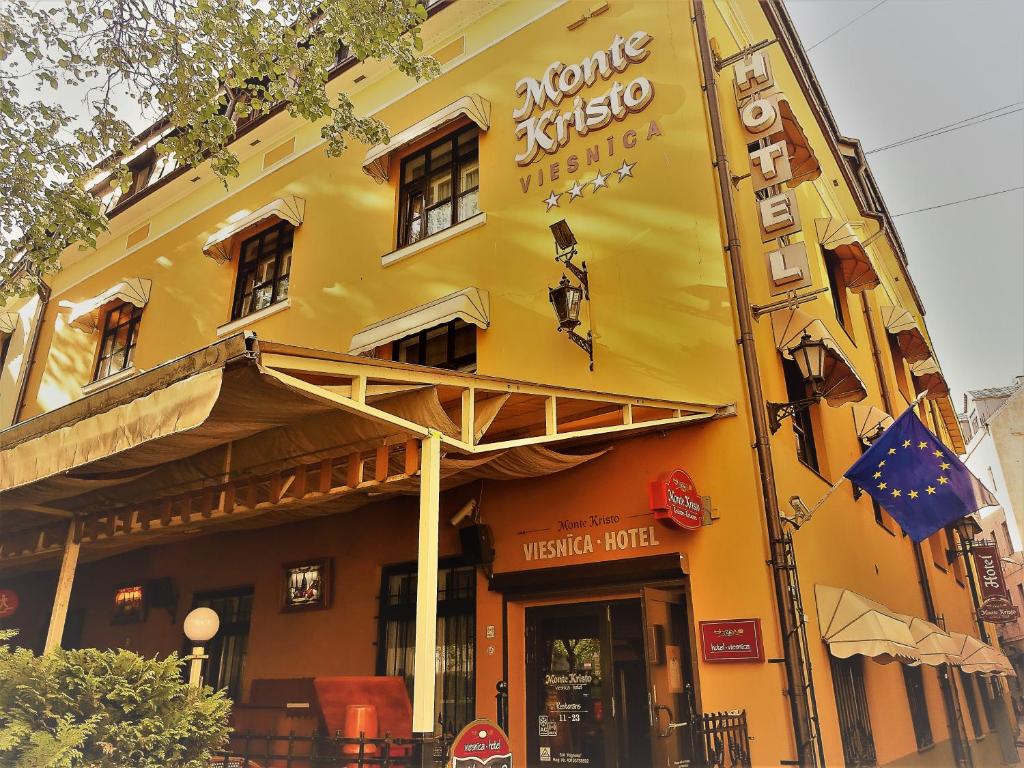 een geel gebouw met een muziekhuis bij Boutique Hotel Monte Kristo in Rīga