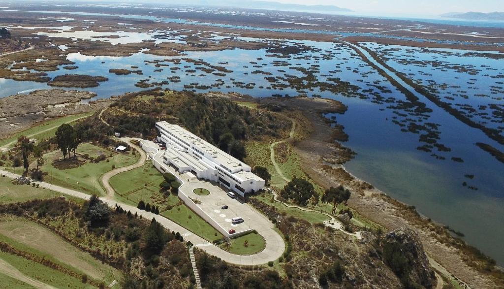 una vista aérea de un edificio en una colina junto al agua en GHL Hotel Lago Titicaca, en Puno