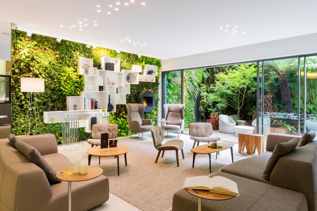 a living room with furniture and a wall of windows at BW Premier Collection Le Saint Antoine Hotel et Spa in Rennes