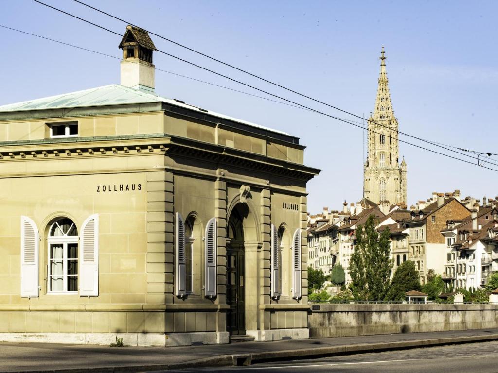 un edificio sul lato di una strada con una chiesa di One Suite Hotel - Zollhaus a Berna