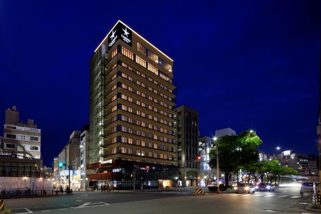 um edifício alto com um relógio no topo em Candeo Hotels Kobe Tor Road em Kobe