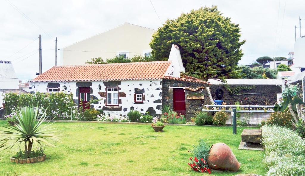 a white house with a yard with a yard sidx sidx sidx at Fisherman's House Azores in Angra do Heroísmo