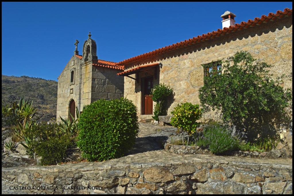 een stenen kerk met een kruis erop bij Castelo Cottages in Castelo Novo