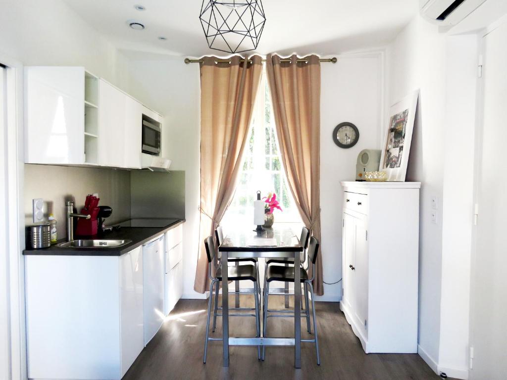 una cocina con una mesa pequeña y una ventana en La petite Maison, en Grenoble