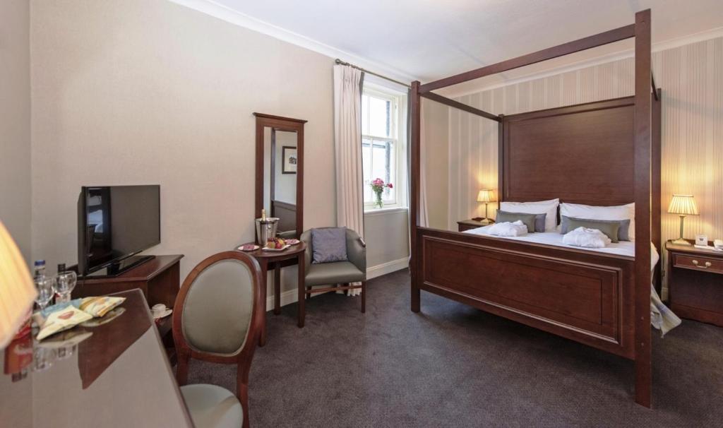 Cette chambre dispose d'un grand lit avec un grand miroir. dans l'établissement Salutation Hotel, à Perth