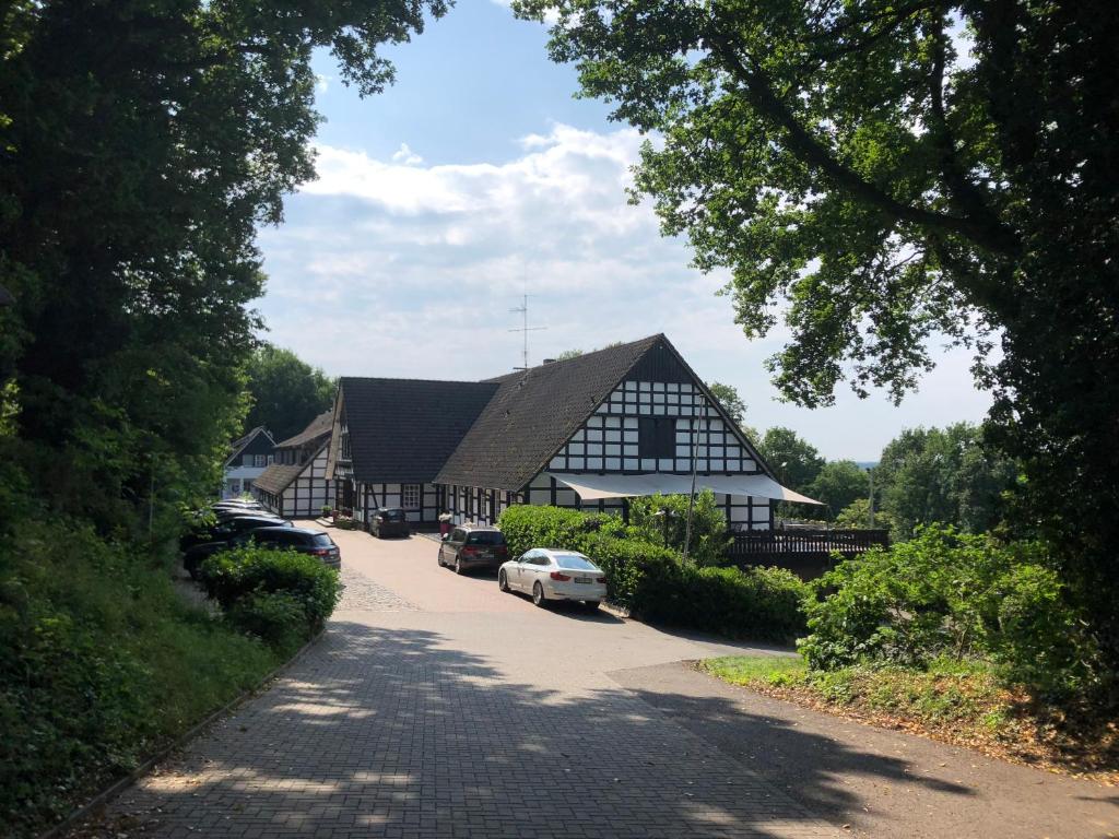 ein großes schwarzweißes Haus mit Autos in einer Einfahrt in der Unterkunft Hotel Niedersächsischer Hof in Bad Bentheim