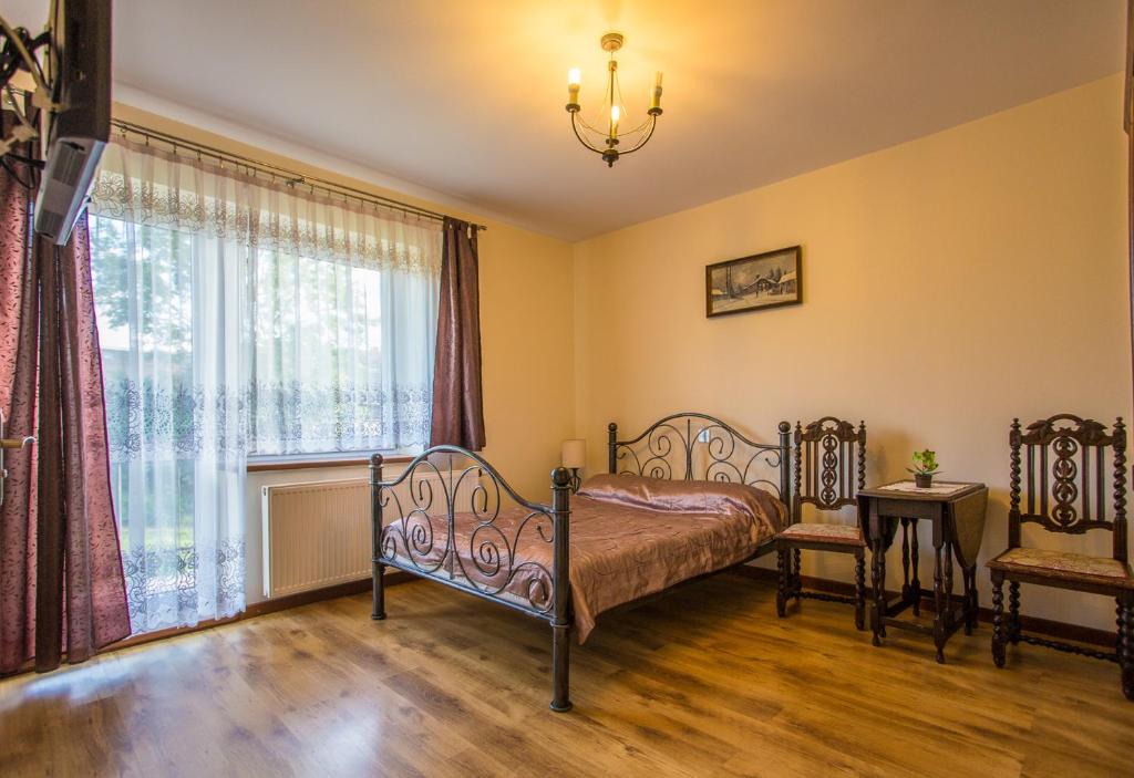 een slaapkamer met een bed en een raam bij Willa Natia in Kluszkowce