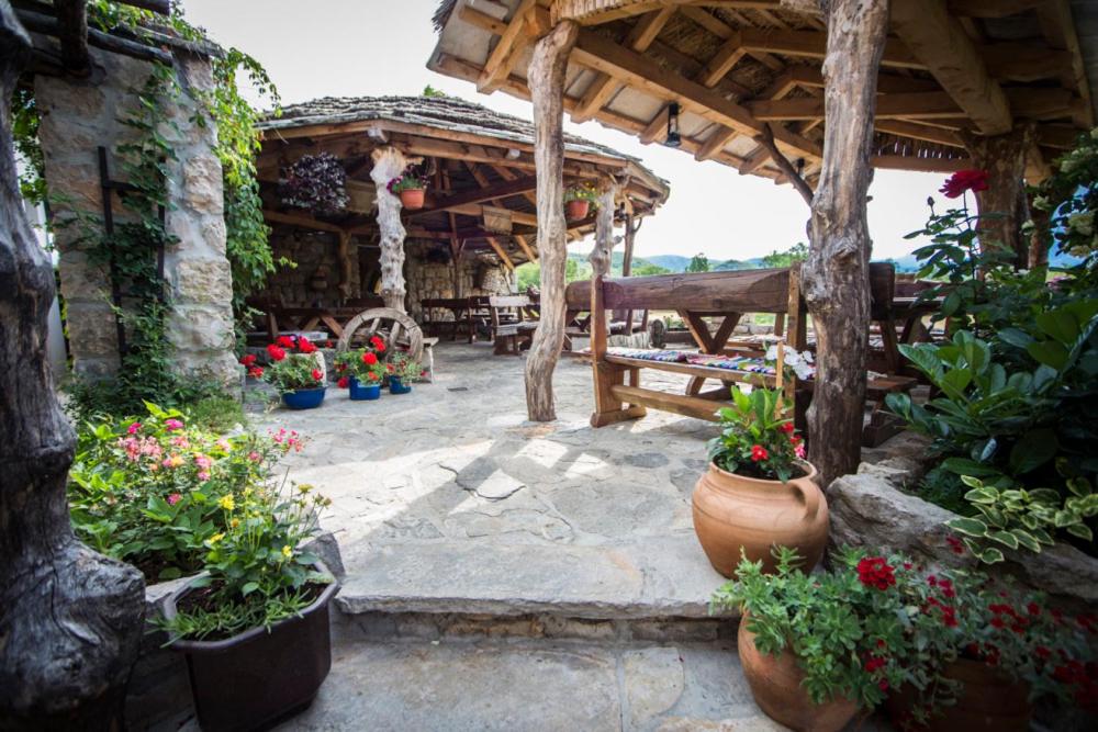 un patio extérieur avec des plantes en pot et un pavillon en bois dans l'établissement Stara Hercegovina, à Trebinje