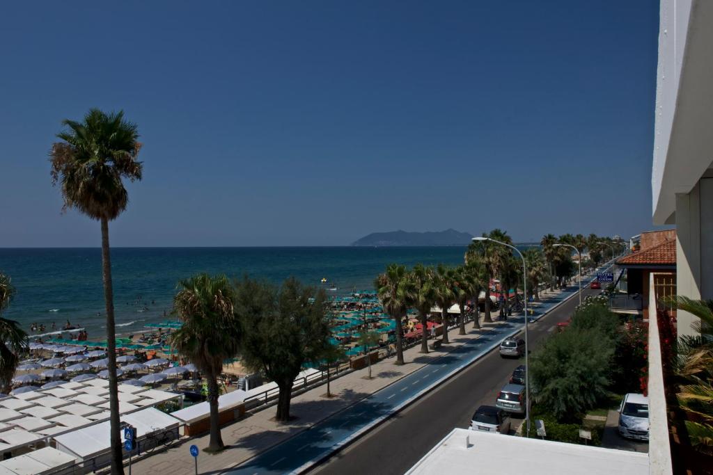 - une vue sur la plage bordée de palmiers et l'océan dans l'établissement Hotel Ristorante Centosedici, à Terracine