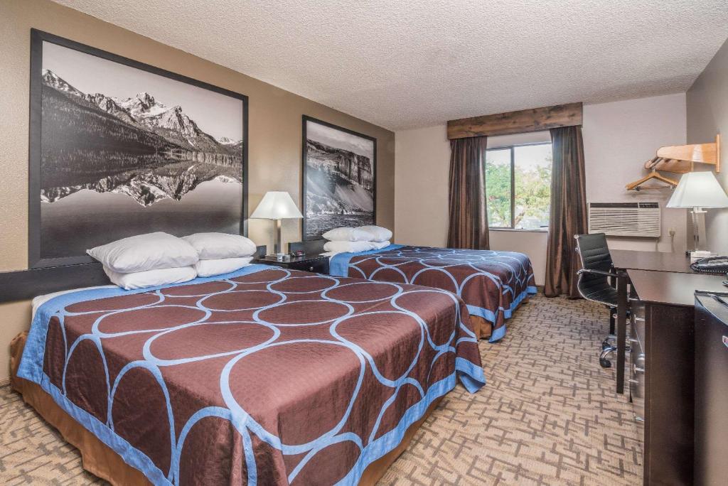 a hotel room with a bed and a desk at Super 8 by Wyndham Boise in Boise