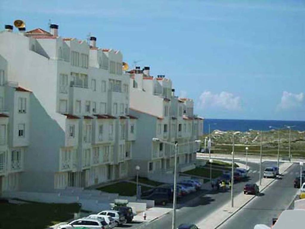 um grande edifício com carros estacionados num parque de estacionamento em Beach and Surf em Peniche