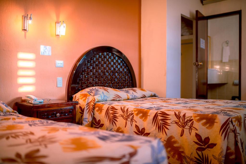 - une chambre avec 2 lits et une tête de lit dans l'établissement Hotel Los Girasoles, à Tepic