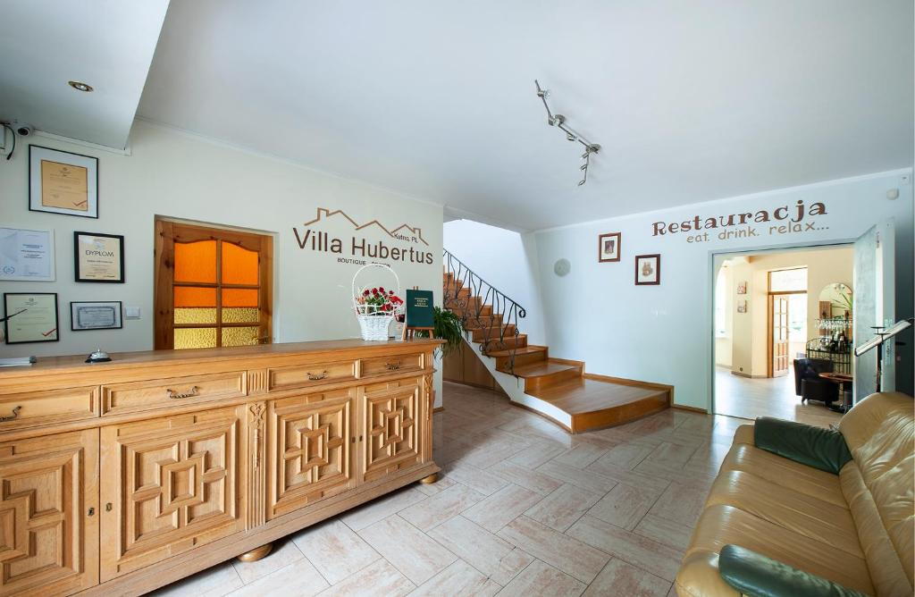 ein Wohnzimmer mit einem großen Holzschrank und einer Treppe in der Unterkunft Hotel Villa Hubertus Kutno in Kutno