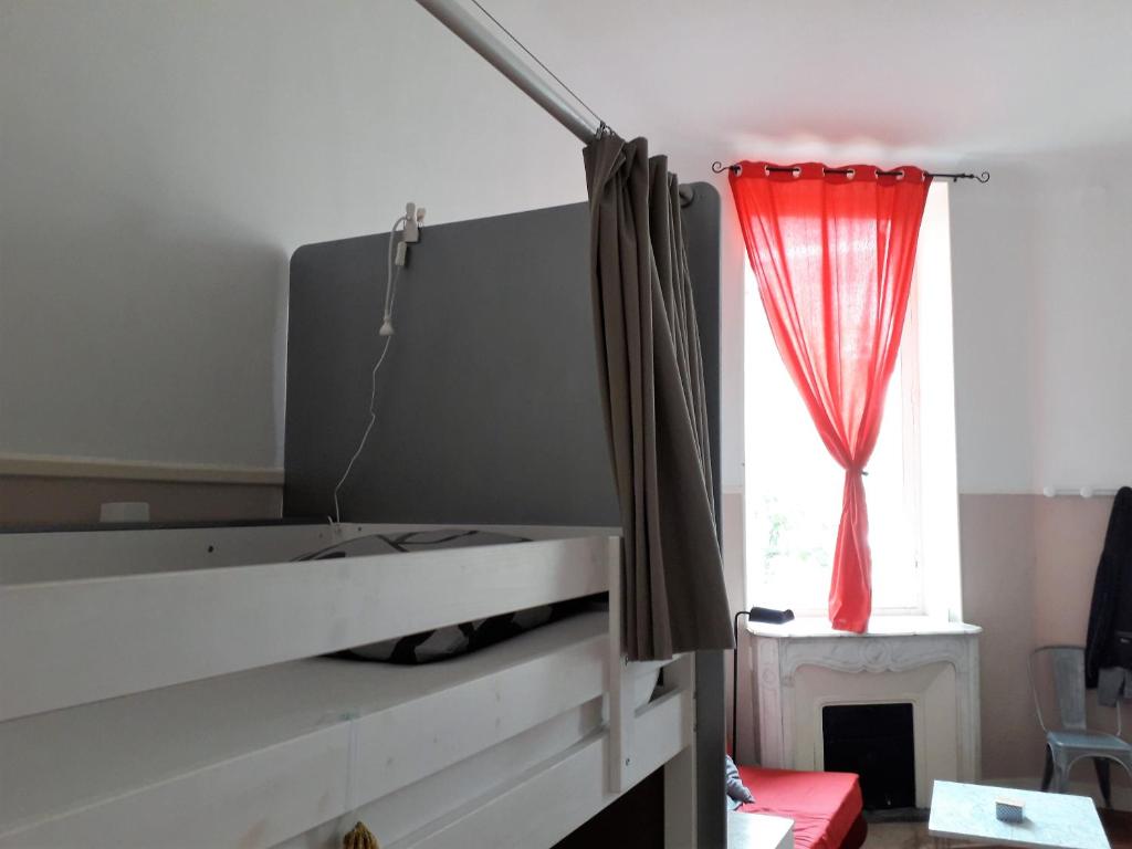 um quarto com uma cama com uma cortina vermelha em La Maïoun Guesthouse em Nice