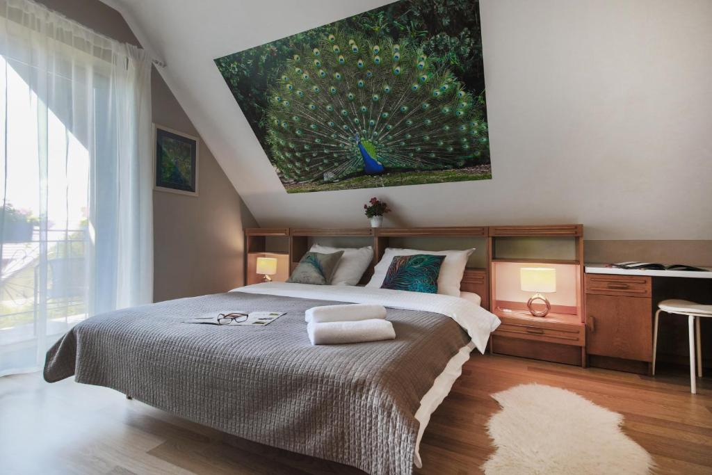 1 dormitorio con 1 cama grande y una pintura en la pared en Villa Aviator, en Jaworze