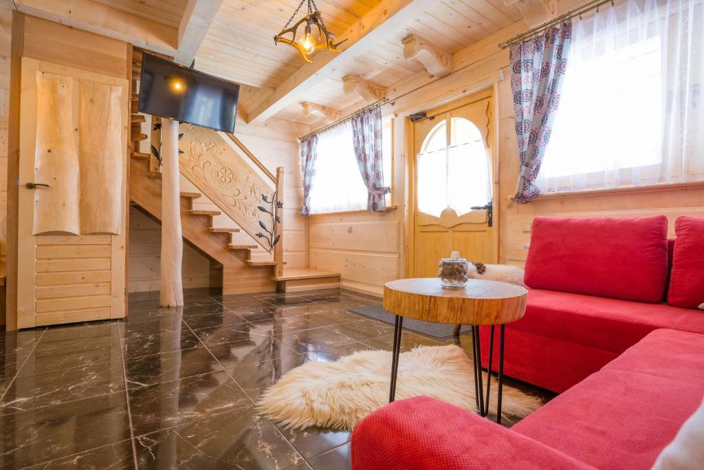 sala de estar con sofá rojo y mesa en Domki u Magdy, en Zakopane