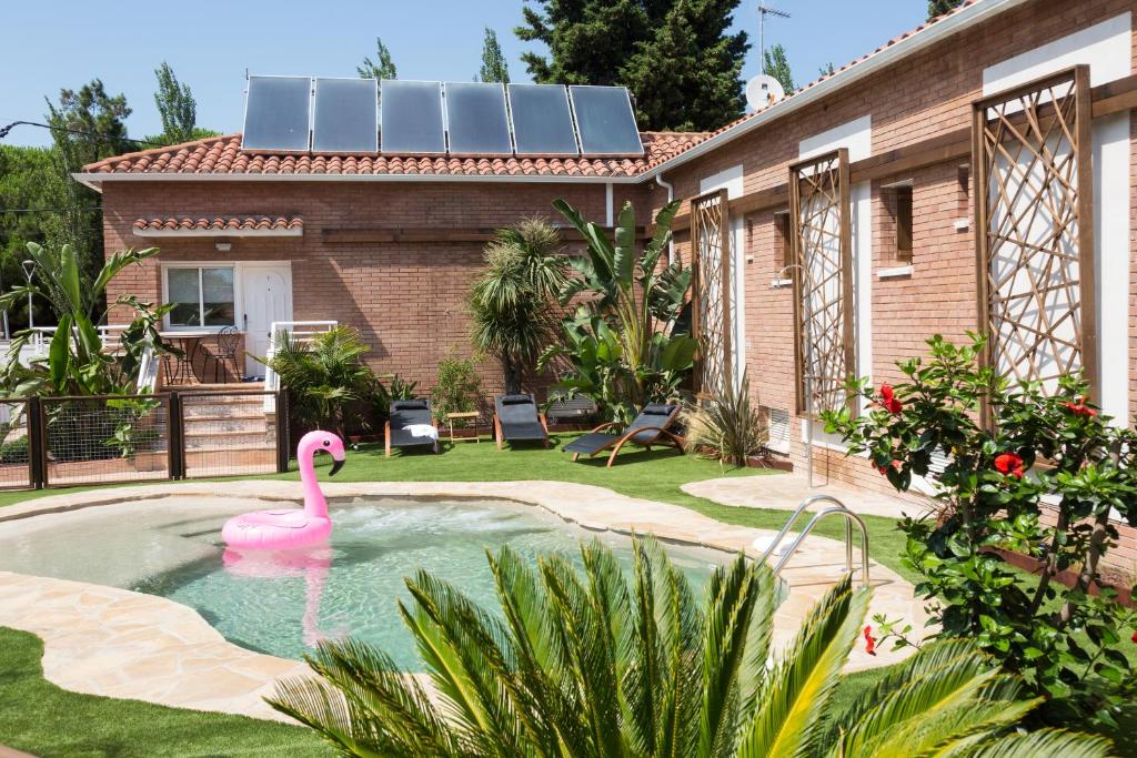 um flamingo rosa numa piscina em frente a uma casa em Rambla de Marisol Apartments em Castelldefels