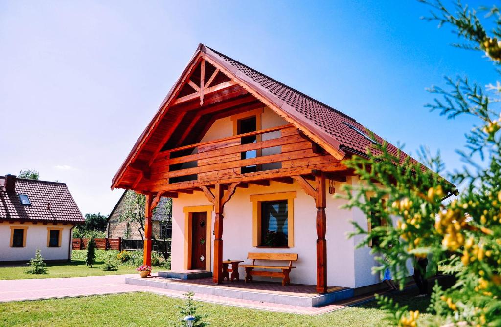 une petite maison avec un toit en bois dans l'établissement Żwirowa Góra - Domki nad Narwią, à Tykocin