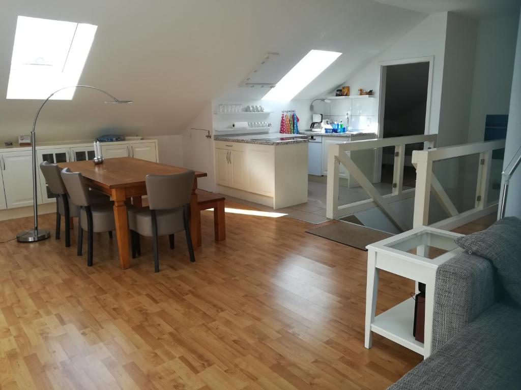 een keuken en een woonkamer met een tafel en een bank bij Ferienwohnung Drabinski in Kiel