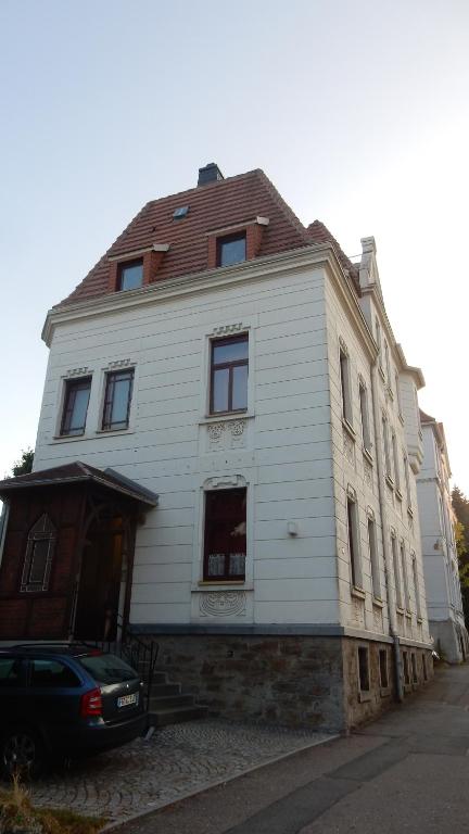 a white house with a car parked in front of it at Ferienwohnung Freiberg, Chemnitzer Straße in Freiberg