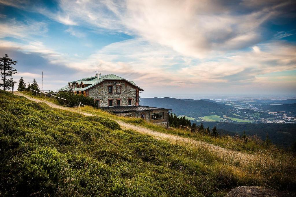 une maison au sommet d'une colline herbeuse dans l'établissement Chata Jiriho na Seraku, à Bělá pod Pradědem