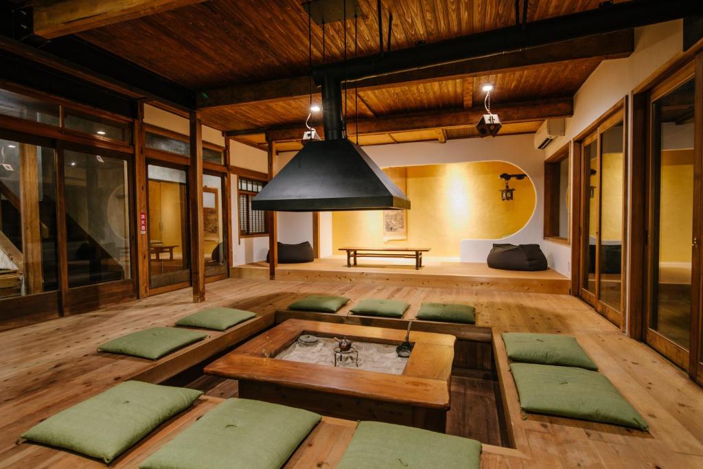 un soggiorno con tavolo e sedie imbottite di verde di Irori Guest House Tenmaku a Hakone